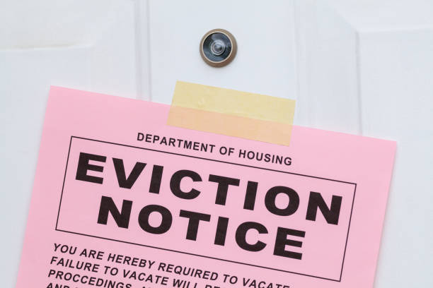 Eviction Notice on Door Close Up Pink Eviction Notice Taped on Front Door Close Up. eviction photos stock pictures, royalty-free photos & images