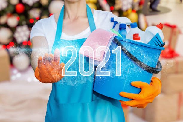 istock Cleaning lady clicks on New Year 2021 . 1287655676