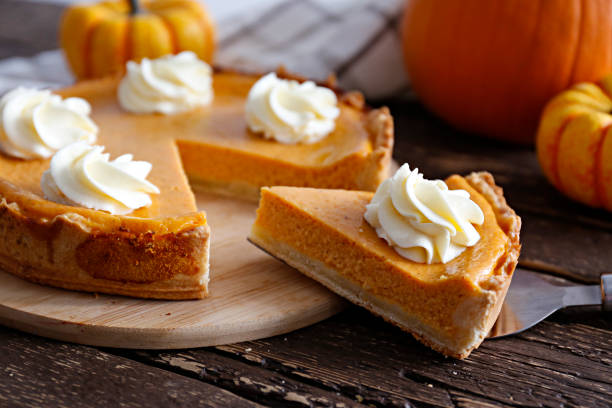 Pumpkin pie made of organic ingredients. Traditional thanksgiving food on wooden table. Orange delicious homemade pumpkin pie with crust and decorative items. Thanksgiving table setting concept.Top view, close up, copy space, background. dessert pie stock pictures, royalty-free photos & images