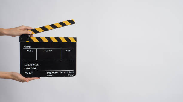 istock Two Hand's holding black with yellow Clapper board on white background. 1287656243