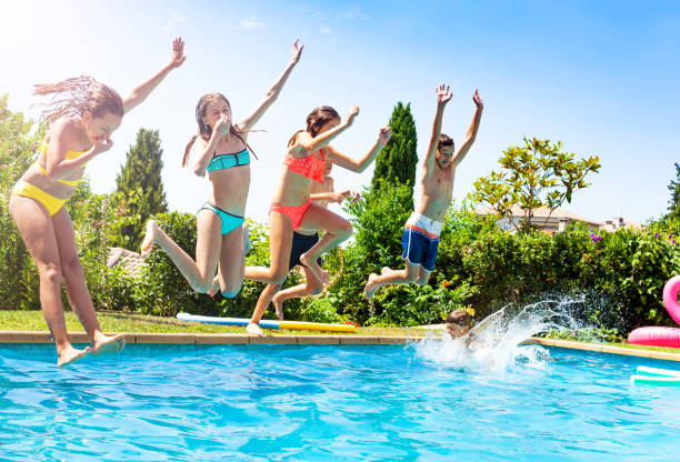 istock Group of fun having kids dive in the water pool 1287657097