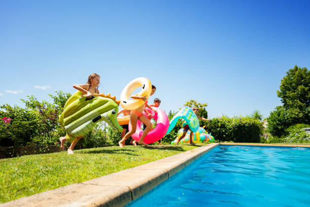 istock Kids with inflatable toys run into swimming pool 1287657112