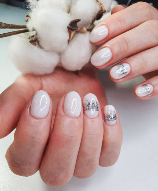 istock White nails with sequins and a silver crown design. White shiny gel polish on round short nails 1287657315