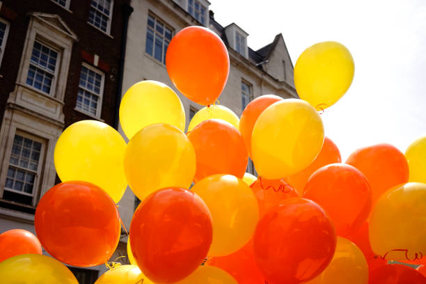 istock Many Balloons Flying to the blue sky 1287657474