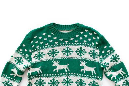 Ugly Christmas sweater concept. Festive jumper with deer and snowflake patterns isolated on white. Close up, top view, flat lay, copy space, background.