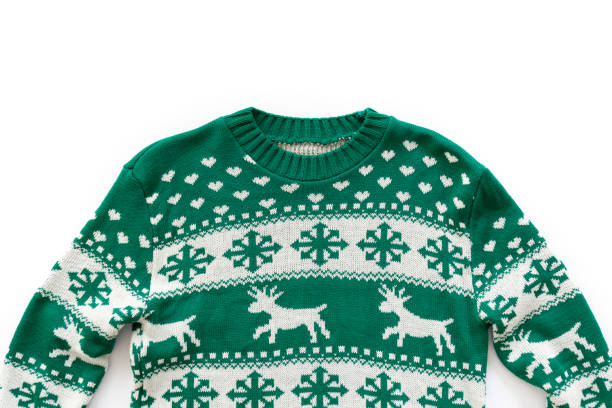 Winter season clothing items. Ugly Christmas sweater concept. Festive jumper with deer and snowflake patterns isolated on white. Close up, top view, flat lay, copy space, background. ugliness photos stock pictures, royalty-free photos & images