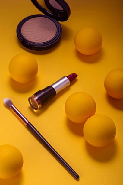 istock Makeup lipstick and cosmetics on yellow background seen from above. 1287657513