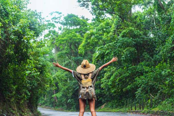 Happy young woman with raised hands on hiking stock photo