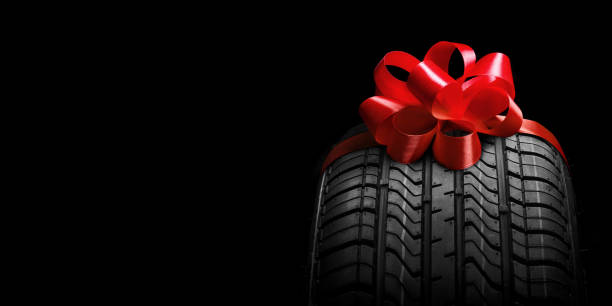 a  black isolation rubber tire, on the grey backgrounds in a bow for christmas stock photo