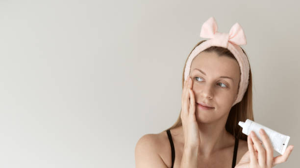 istock Woman applying cream on face. 1287668900