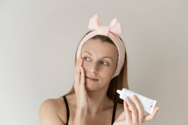 istock Woman applying cream on face. 1287668914