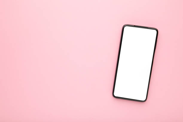 istock Black mobile smartphone with blank screen on pink background. 1287672008