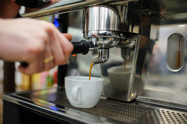istock Closeup of a man barista brewing an espresso using a coffee machine 1287673544