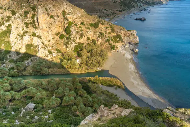 Photo of Preveli beach (aka., Palm Beach) at the mouth of the Megas river flowing through a gorgeous palm tree glade along the Kourtaliotiko gorge, Southern Crete, Greece