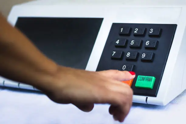 In this photo illustration a woman simulates a vote in the electronic ballot box used in the elections of Brazil.