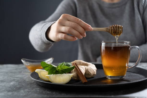 istock Pouring honey into the tea.Tea with honey lemon ginger mint and cinnamon stock image 1287683295