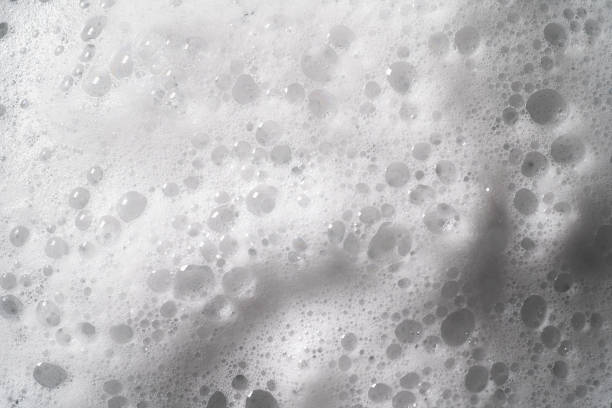 istock White foam with bubbles texture, soap, detergent or shampoo or cleanser surface, macro shot. Body care concept 1287684297