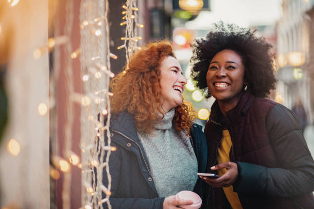 istock Two female friends outdoors during winter using smart phone 1287685312