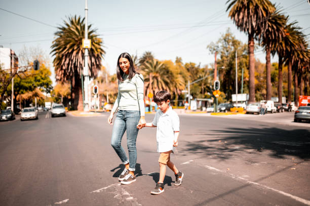 istock Mother and son crossing the street 1287686897