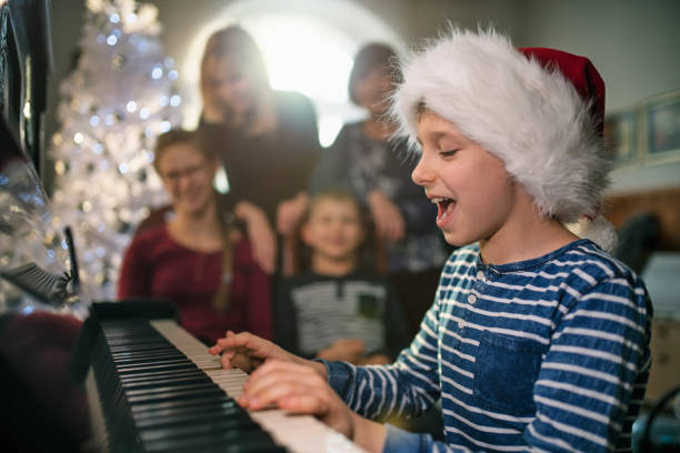 kleiner junge spielt und singt weihnachtslieder - traditional song stock-fotos und bilder