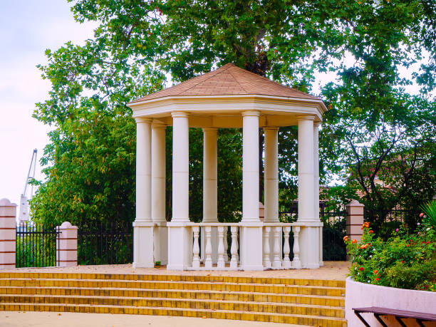 istock A gazebo with white columns stands under green trees in a city park 1287689197