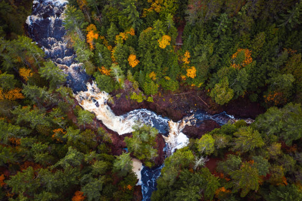 istock Beautiful look down aerial over Brownstone Falls on Tyler Forks river as it merges with the Bad River with colorful fall foliage and red rock lining the river banks in autumn at Copper Falls park. 1287690607