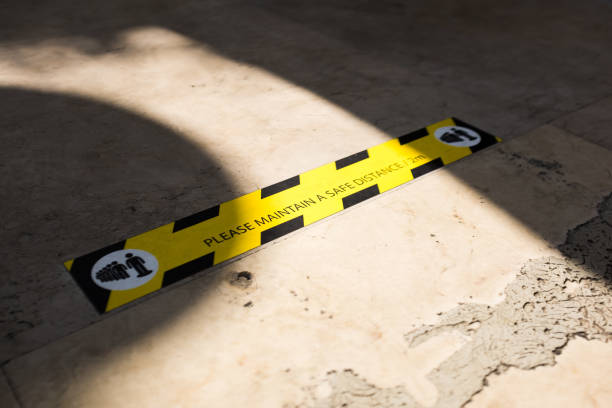 istock MAINTAIN A SAFE DISTANCE sign on the ground 1287693008
