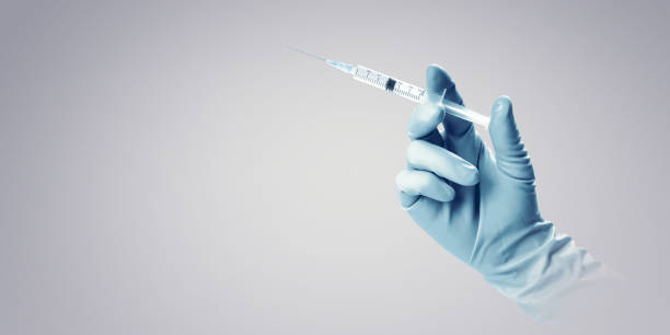 istock Hand holding syringe with vaccine against corona virus. 1287696169