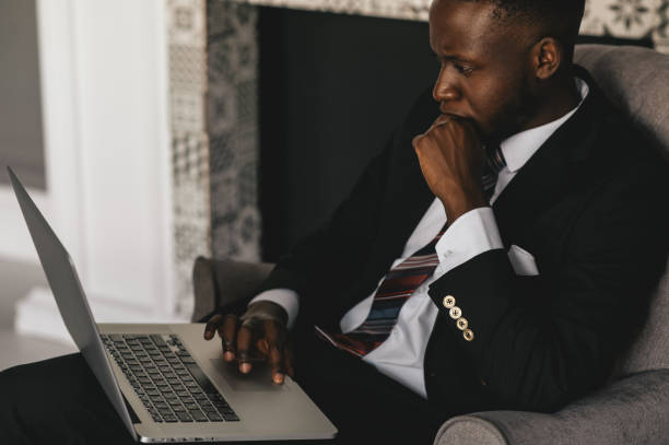 istock Black Businessman using laptop for analyzing data stock market, forex trading graph, stock exchange trading online, financial investment concept. close up 1287696501