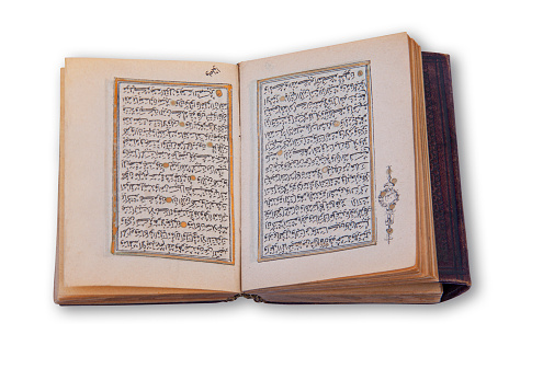 Old arabic holy Quran also romanized Qur'an or Koran, is the central religious text of Islam. Antique book  with hand coloring in gold. Image showing two pages opened up in a spread.