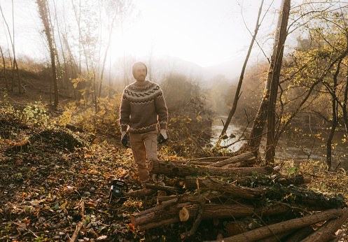Photo of young man chopping firewood by himself for a winter season
