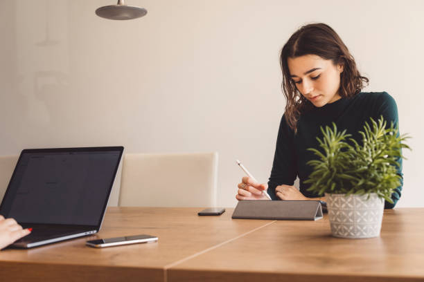 istock Caucasian woman using a pen to draw on digital tablet 1287698914