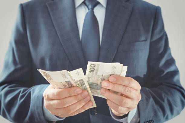 istock Man in a suit counts Polish banknotes 1287699409
