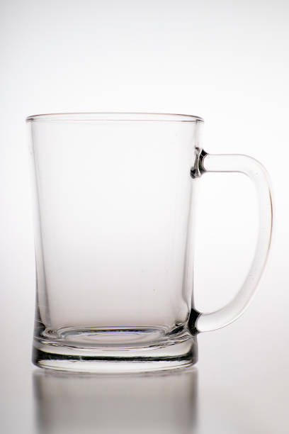 istock Pouring water into a mug. Glass container for weak carbonated alcohol. Light background. 1287701072