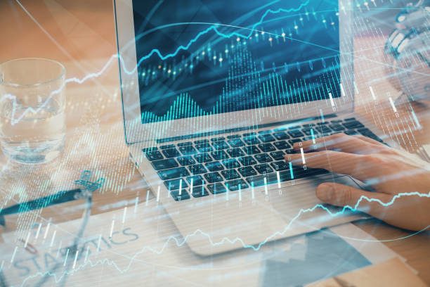 istock Multi exposure of market chart with man working on computer on background. Concept of financial analysis. 1287705179