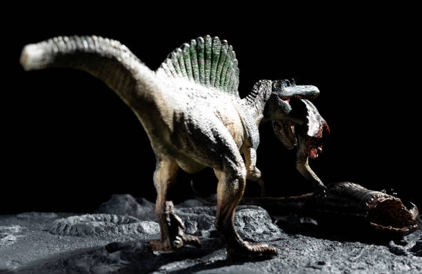 istock spinosaurus bitting a tenontosaurus body on a ground with craters 1287706079