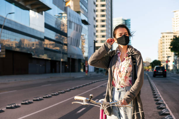 istock woman with a bike adjusting her protective mask 1287706155