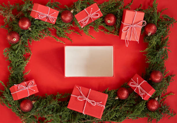 istock Flat lay new year Christmas red boxes, red balls and pine tree branches on red paper background 1287706347