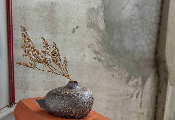 istock Dried flowers in Handmade Ceramic Vases and books on table. 1287706458