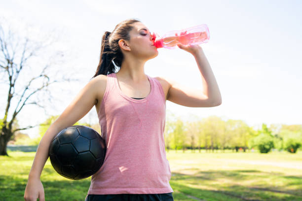 istock Female soccer player drinking water from bottle. 1287722710