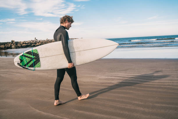 istock Surfer standing in the ocean with his surfboard. 1287723043