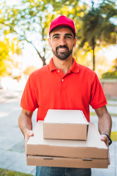 istock Delivery man with pizza box outdoors. 1287723064