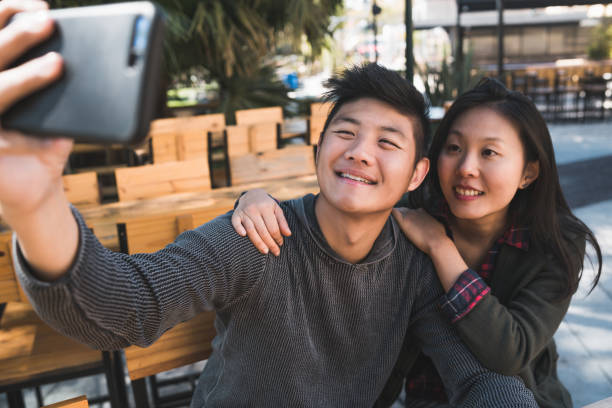 istock Asian couple taking a selfie with mobile phone. 1287725882
