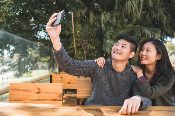 istock Asian couple taking a selfie with mobile phone. 1287725888