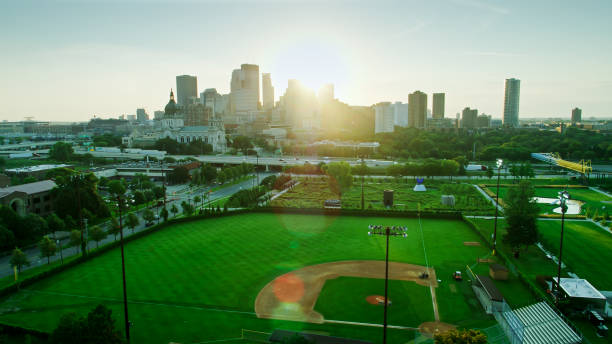 vue à travers le terrain de base-ball vers minneapolis du centre-ville au lever du soleil - baseball diamond flash photos et images de collection