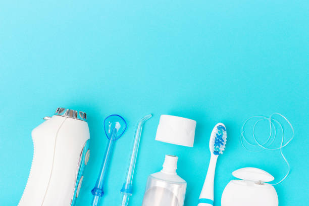 istock Toothpaste, toothbrush and dental irrigator on blue background with copy space. 1287728157