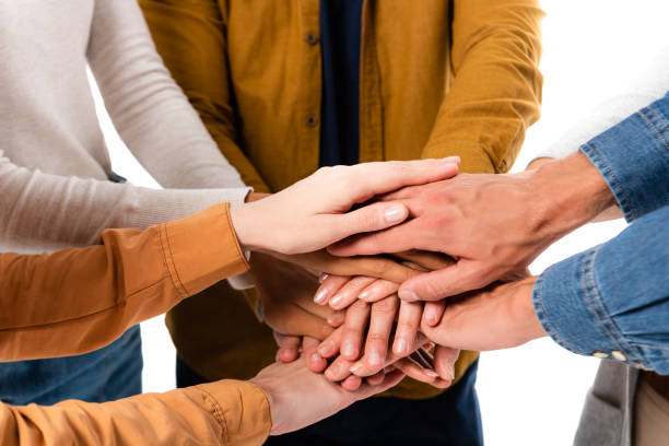 istock Cropped view of multicultural people holding hands isolated on white 1287728338