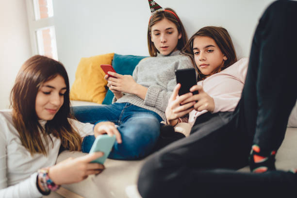 traîner avec des amis à la maison, en utilisant des téléphones cellulaires - 12 15 months photos et images de collection