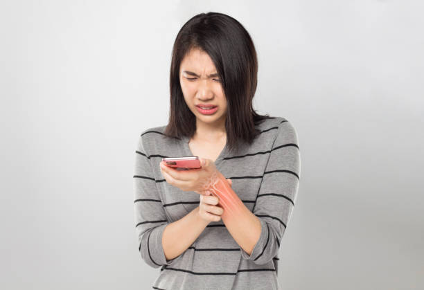 istock woman holding mobile wrist bones pain 1287755416