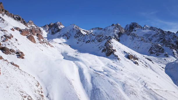 снежные горные вершины со скалами. вид с беспилотника - kazakhstan glacier snow mountain view стоковые фото и изображения